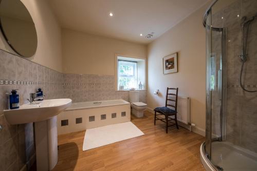 y baño con bañera, lavamanos y ducha. en Lochsie Cottage, en Portree