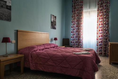 a bedroom with a bed and a window with curtains at Bellarmino Boutique Apartments, Montepulciano in Montepulciano