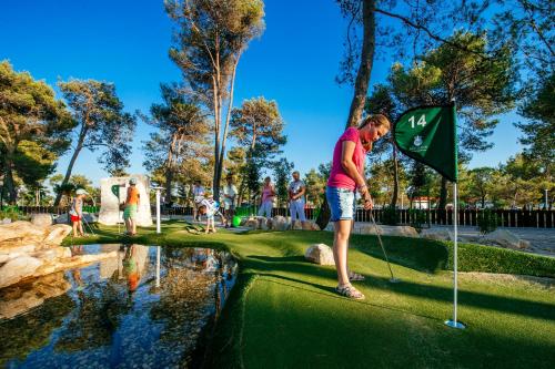 a man is playing golf on a putting green at Zaton Holiday Resort in Nin