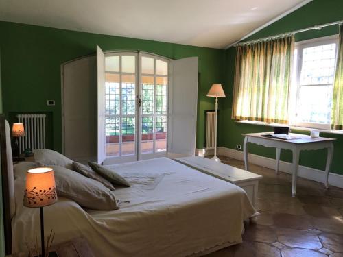 a green bedroom with a bed and a table at Borgo del Gelso in Olgiata