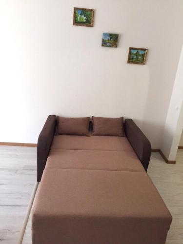 a couch in a room with three pictures on the wall at Polyana Apart in Polyana