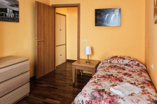 a bedroom with a bed and a table with a lamp at Bellarmino Boutique Apartments, Montepulciano in Montepulciano