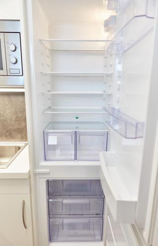 a white refrigerator with empty drawers in it at Appartement Diamond in Saalbach-Hinterglemm