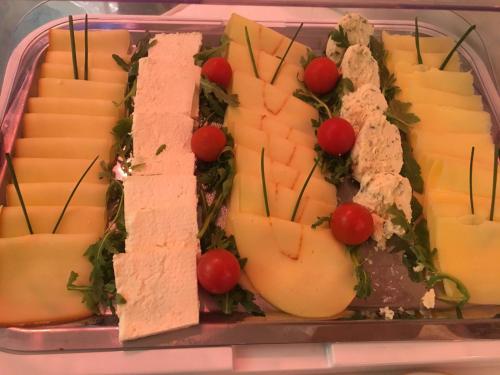 a tray with cheese and tomatoes on it at Hotel Splendid 1900 in Craiova