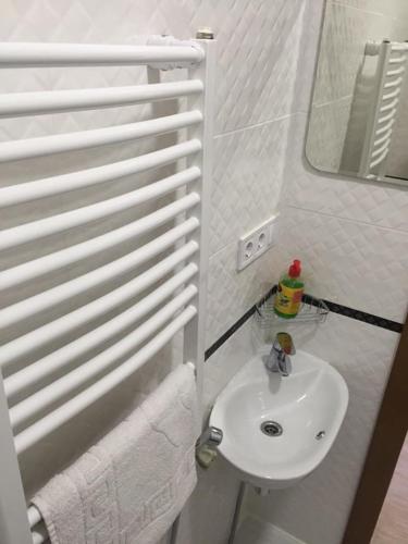 a white bathroom with a sink and a mirror at Polyana Apart in Polyana