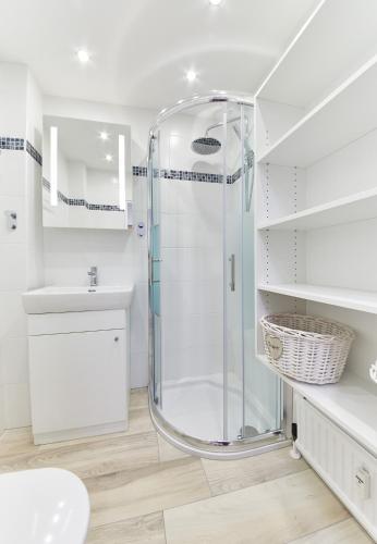 a white bathroom with a shower and a sink at Appartement Hotspot in Saalbach-Hinterglemm