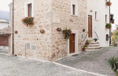 a stone building with flowers on the side of it at La Palummara in San Panfilo dʼOcre