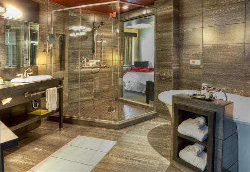 Grand Times Hotel في مدينة كيبك: حمام مع دش وحوض استحمام ومغسلة