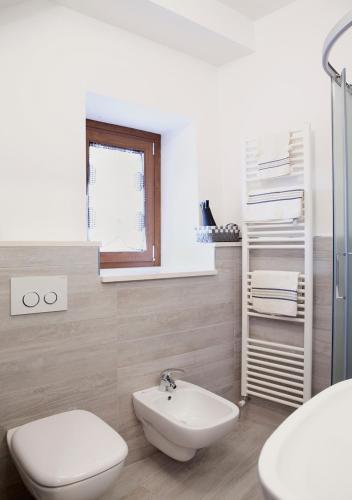 a white bathroom with a toilet and a sink at La Palummara in San Panfilo dʼOcre
