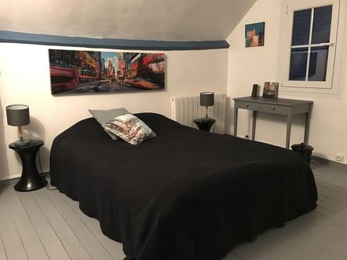 - une chambre avec un lit doté d'une couverture noire et d'une table dans l'établissement Villa Fleurs de France, à Criel-sur-Mer