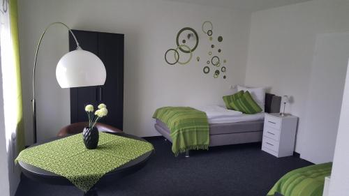 ein Schlafzimmer mit einem Bett, einem Tisch und einem Stuhl in der Unterkunft em Dorfkrug in Euskirchen