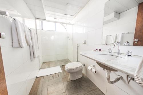 uma casa de banho branca com um WC e um lavatório em Phenícia Bittar Hotel em Brasília
