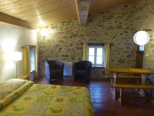 1 dormitorio con 1 cama, mesa y sillas en Mas Taillet Maison d'Hôtes, en Prats-de-Mollo-la-Preste
