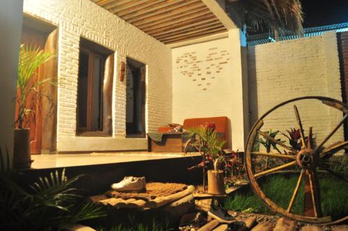 a model of a house with a wheel in front of it at Mu Homestay in Tetebatu