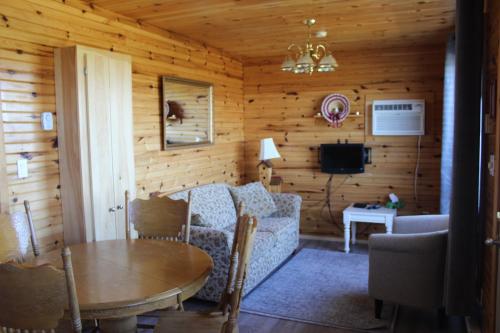 sala de estar con sofá y mesa en Chalets Grand Pre Cottages, en North Rustico