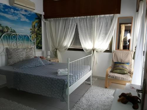 1 dormitorio con cama, ventana y silla en Shared Top 1st floor villa, en Limassol