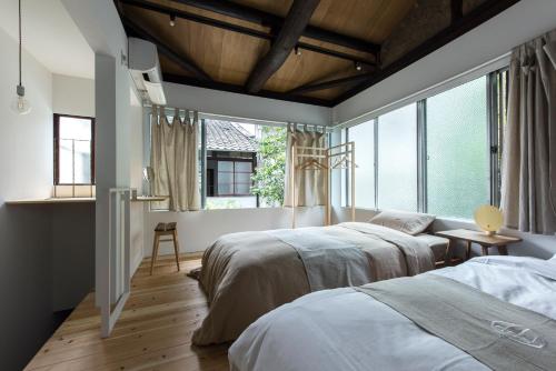 a bedroom with two beds and a large window at A day in khaki in Kyoto