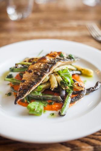 a white plate with a seafood dish on a table at The Swan in Wedmore
