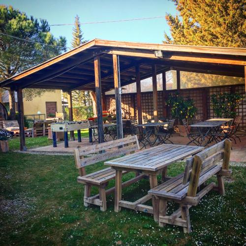 a picnic table and benches in front of a pavilion at Podere Casanova in Montespertoli