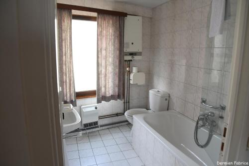 La salle de bains est pourvue d'une baignoire, de toilettes et d'un lavabo. dans l'établissement L'Auberge Saint Remacle, à Stavelot