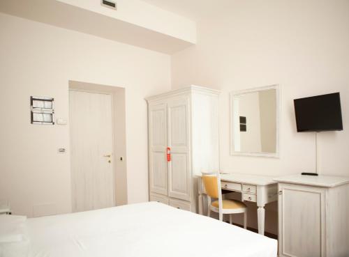 a white bedroom with a desk and a bed at Hotel Sebino in Sarnico