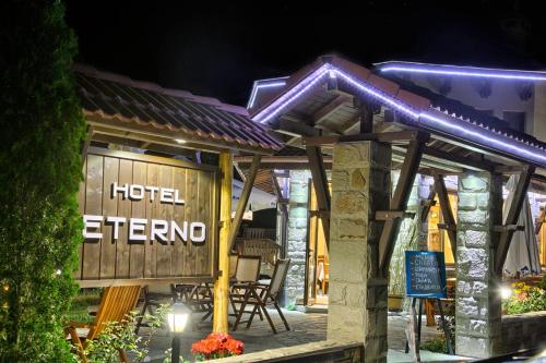 a hotel exterior at night with a table and chairs at Family Hotel Eterno in Tsigov Chark
