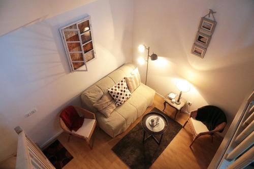 vistas panorámicas a una sala de estar con sofá y sillas en La Poussiniere, en Auvers-Saint-Georges