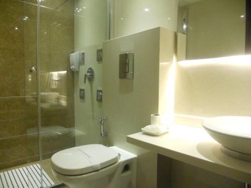 a bathroom with a toilet and a shower and a sink at Hotel Grand Godwin - Free Airport Pick-Up in New Delhi