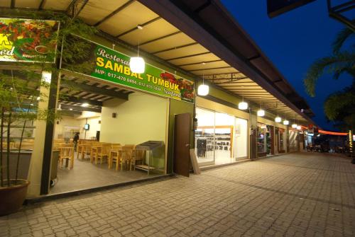 a restaurant with tables and chairs inside of a building at Casa Fina Fine Homes in Pantai Cenang