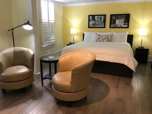 a bedroom with a bed and two chairs and a table at The Sherman Inn in Batesville