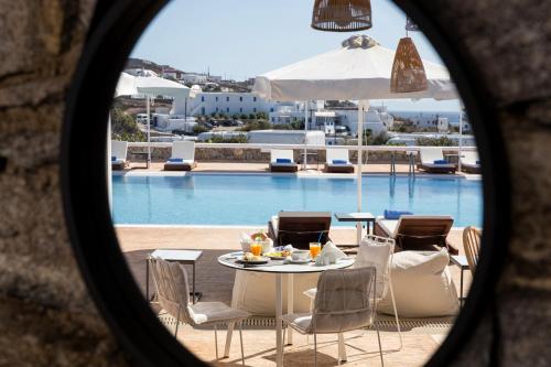 a table and chairs in front of a pool at Osom Resort in Ornos