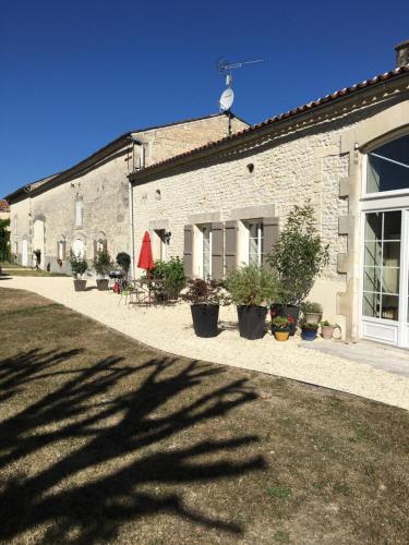 a brick building with potted plants in front of it at Logis de L'Arceau in Celles