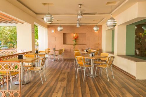 um restaurante com mesas e cadeiras de madeira em Hotel Miraflores Villahermosa em Villahermosa