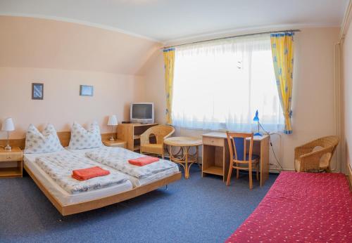 Habitación de hotel con 2 camas, mesa y sillas en Rekreačný Dom Mengusovce, en Mengusovce