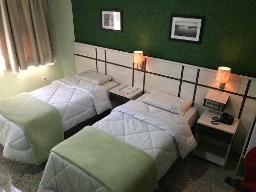 três camas num quarto com paredes verdes em Residencial Pantanal Santa Cruz em São Paulo