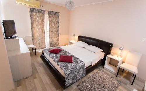 Un dormitorio con una cama con almohadas rojas. en Hotel Aqua Panon en Kanjiža