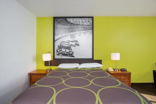 a hotel room with a bed with a picture on the wall at Super 8 by Wyndham Franklin in Franklin