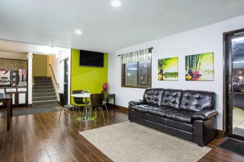 a living room with a leather couch and a table at Super 8 by Wyndham Franklin in Franklin