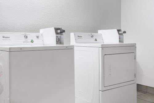 two washing machines sitting next to each other in a room at Super 8 by Wyndham Franklin in Franklin