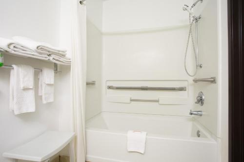 a white bathroom with a bath tub and towels at Super 8 by Wyndham Franklin in Franklin