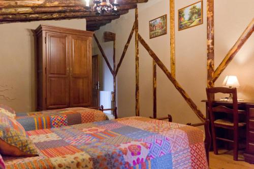 a bedroom with a bed and a wooden cabinet at Casa La Plaza in Armuña