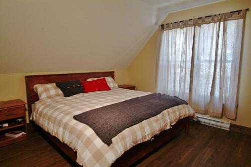 une chambre avec un lit et une fenêtre dans l'établissement Chalet 9014 Chemin des Alpages by Les Chalets Alpins, à Stoneham