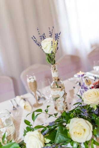 a table with a vase with flowers on it at Ranč pod Ostrou Skalou in Stratená