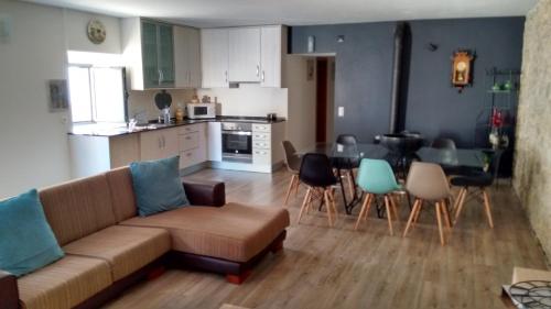 ein Wohnzimmer und eine Küche mit einem Sofa und einem Tisch in der Unterkunft Casa Centenaria in Serra d’El-Rei