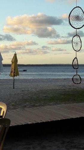 a view of a beach with an umbrella and the ocean at Albergue da Gamboa in Morro de São Paulo