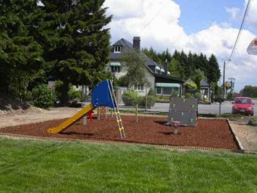 a playground with a slide in a yard at Hotel Aux Massotais in Petites Tailles