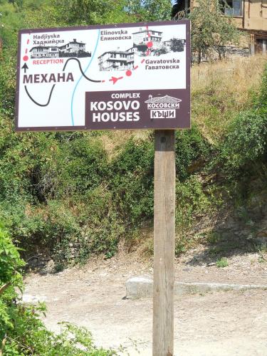a sign on a wooden pole in the dirt at Complex Kosovo Houses in Kosovo