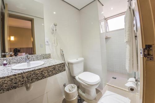 América Bittar Hotel في برازيليا: حمام ابيض مع مرحاض ومغسلة