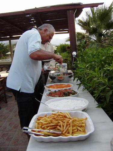 a man preparing a buffet of food on a table at Alex in Karpathos Town