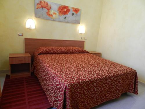 a bedroom with a bed with a red bedspread at Hotel Air Palace Lingotto in Turin